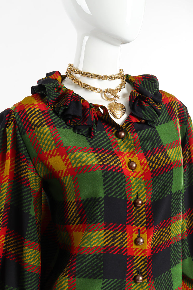 Heart charm necklace by Givenchy on white background on mannequin with plaid shirt @recessla