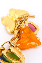 Charm bracelet by Givenchy on white background orange heart and butterfly close @recessla