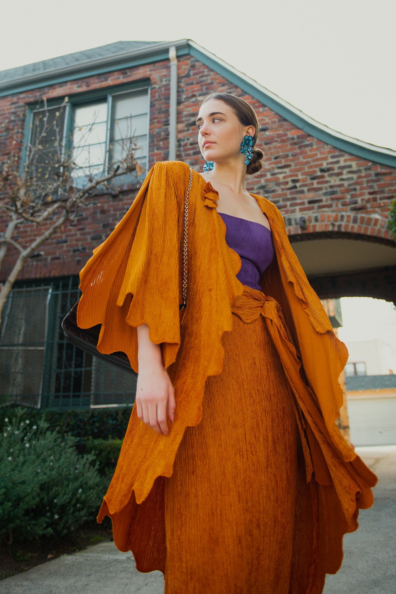 Girl in vintage Holly's Harp chenille jacket and skirt from Recess in front of brick building