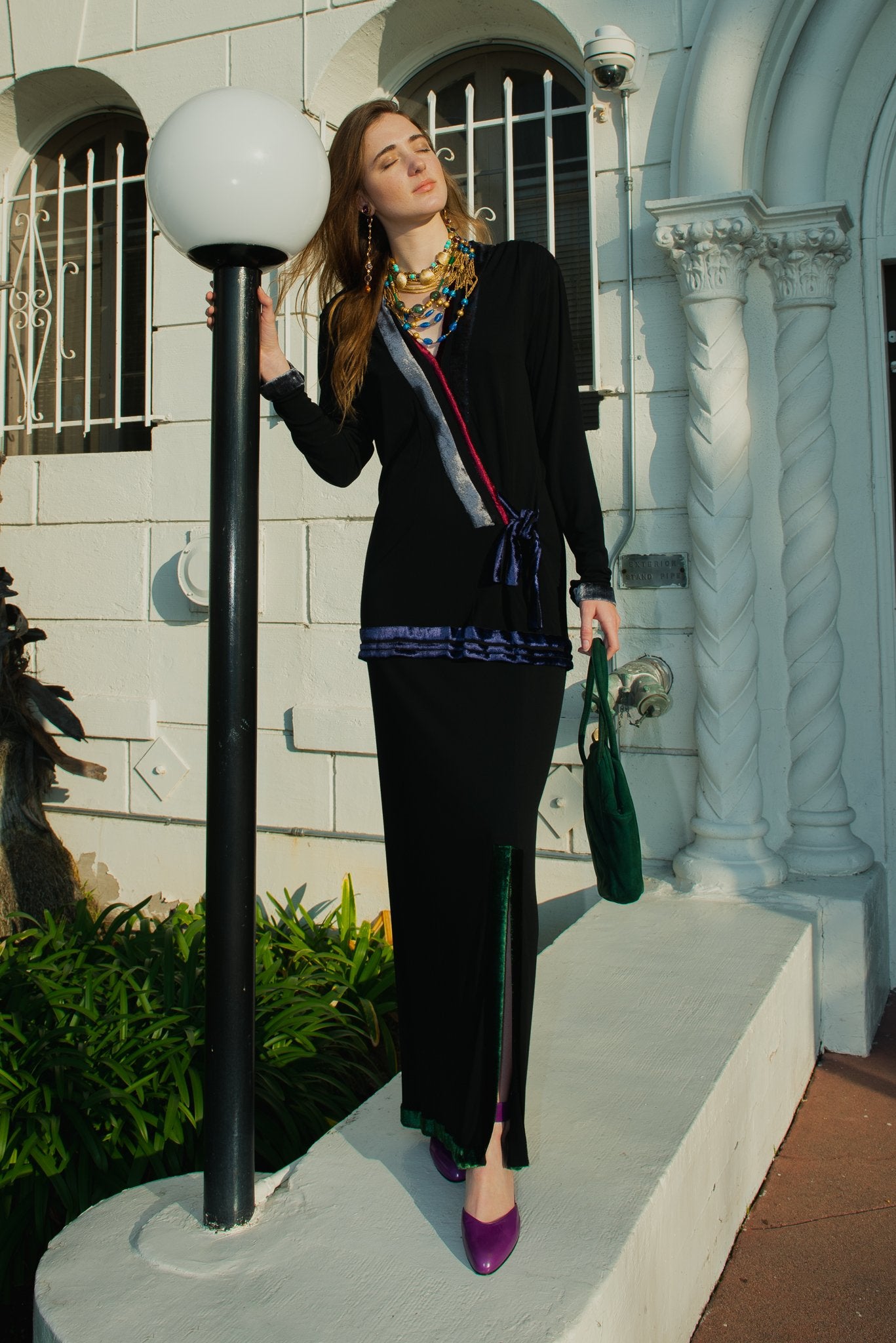 Girl in vintage Janice Wainwright top and skirt set from Recess standing by light post